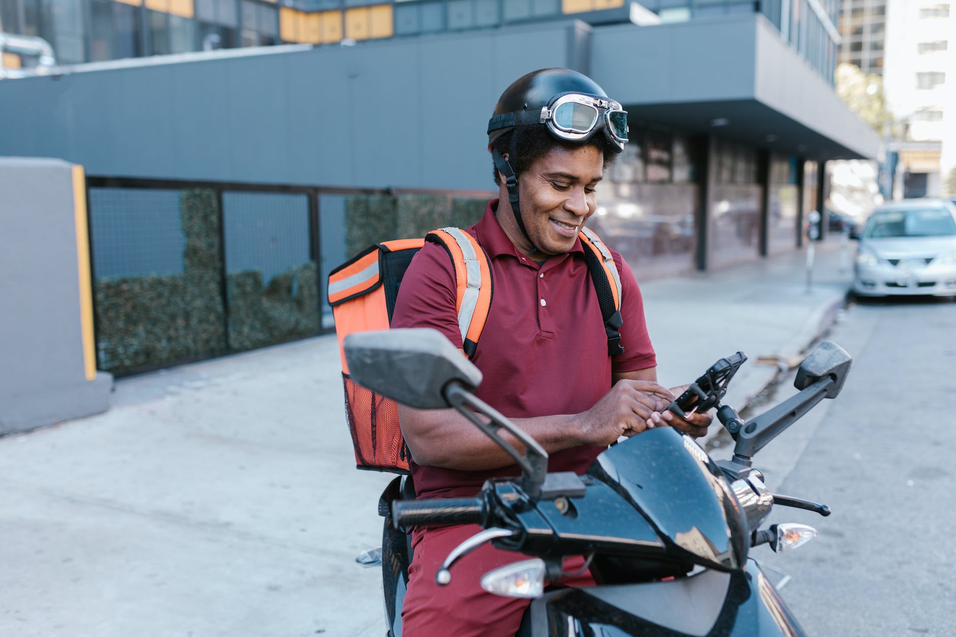 delivery man smiling while looking at his smartphone